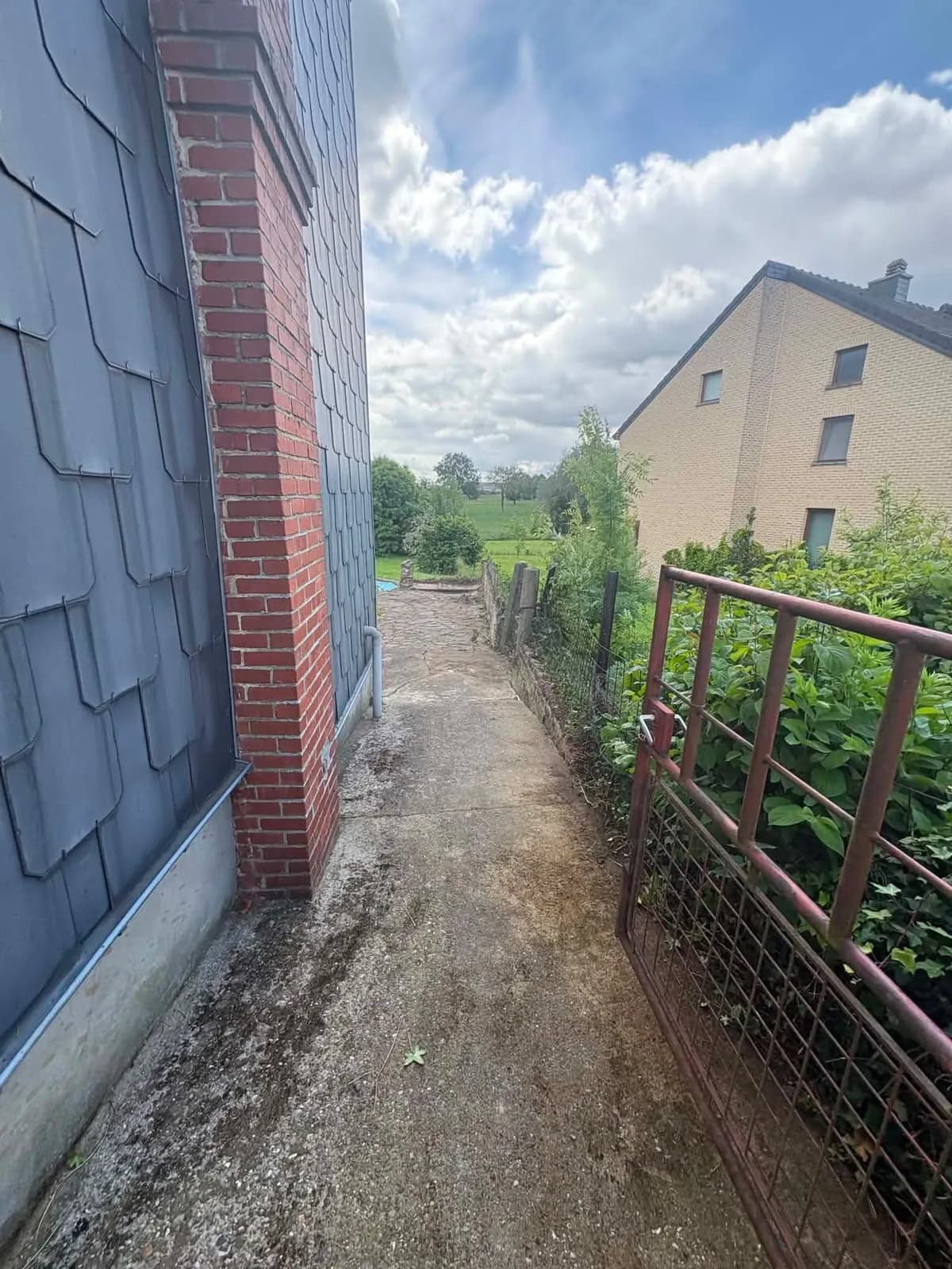 Passage en béton nettoyé le long d’une maison